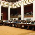 팔레스타인 독립 선언의 의미 - The scene is set indoors, in a large, formal assembly hall with a high ceiling and subtle, classical...